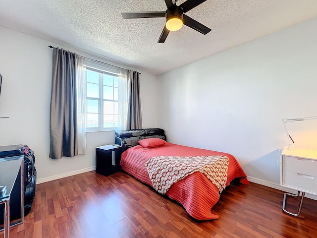 bedroom with ceiling fan, dark hardwood / wood-style flooring, and a textured ceiling