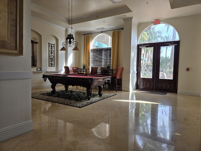 entrance foyer with pool table, ornamental molding, a tray ceiling, and french doors