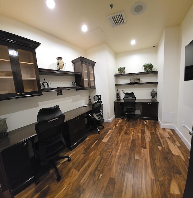 office area with built in desk and dark wood-type flooring