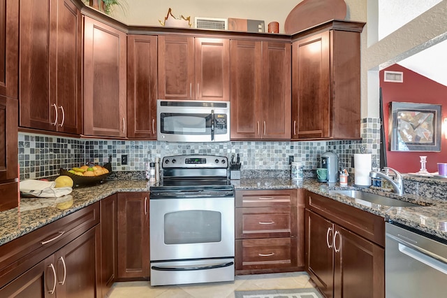 kitchen with stone counters, decorative backsplash, sink, and appliances with stainless steel finishes