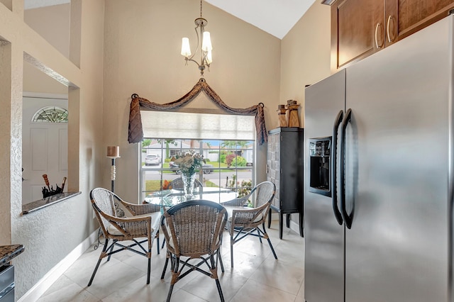 tiled dining room featuring an inviting chandelier and high vaulted ceiling