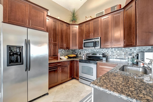 kitchen featuring decorative backsplash, dark stone counters, stainless steel appliances, sink, and lofted ceiling