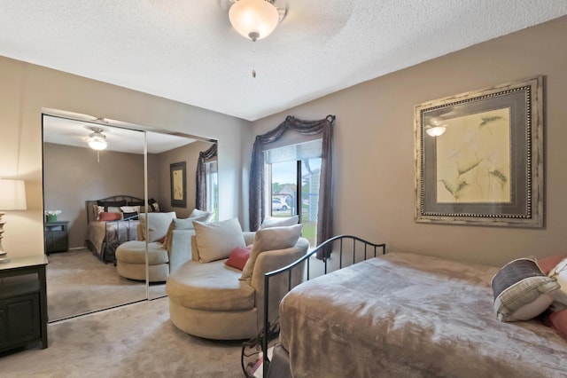 carpeted bedroom featuring a textured ceiling and a closet