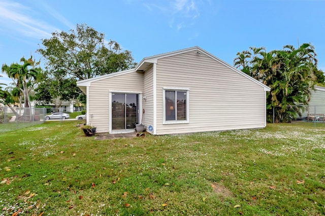 rear view of property featuring a lawn