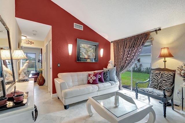 living room with a textured ceiling and vaulted ceiling