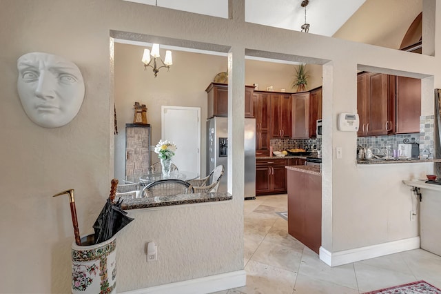 kitchen featuring hanging light fixtures, tasteful backsplash, a notable chandelier, stainless steel fridge, and light tile patterned flooring