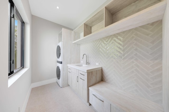 laundry area with stacked washer and dryer and sink