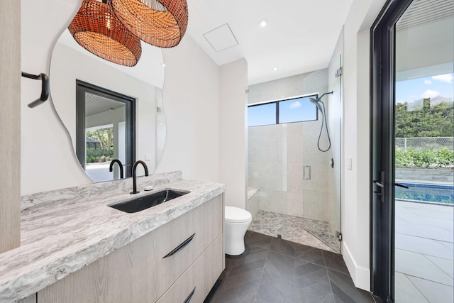 bathroom featuring toilet, walk in shower, and vanity