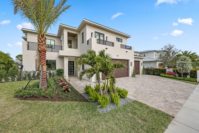 contemporary home with a garage, a balcony, and a front yard