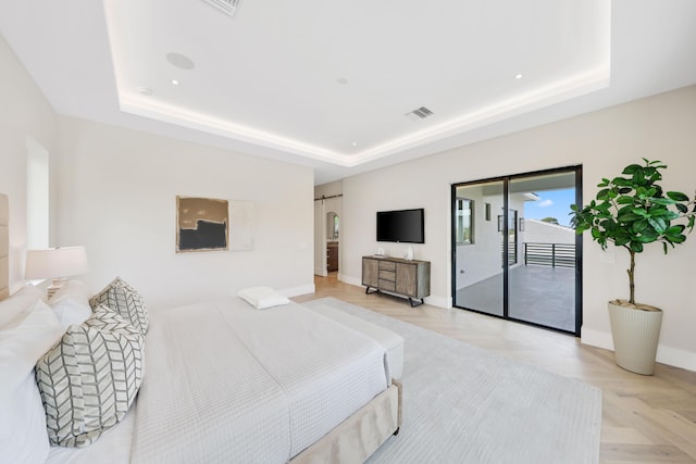 bedroom featuring a raised ceiling, access to exterior, and light parquet floors