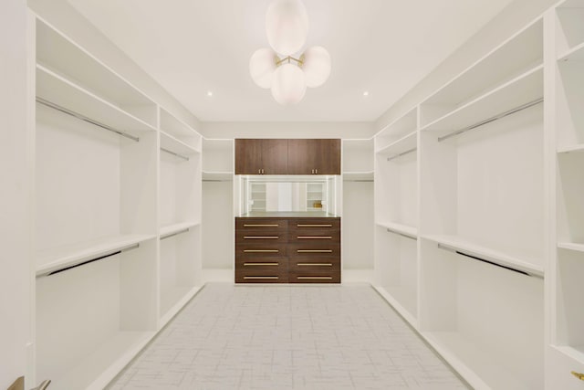 spacious closet with an inviting chandelier