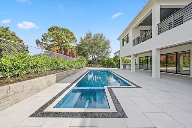 view of swimming pool featuring a patio and an in ground hot tub