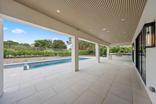 view of pool featuring a patio area and an outdoor kitchen