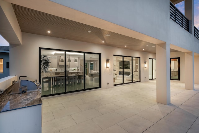 patio terrace at dusk featuring an outdoor kitchen