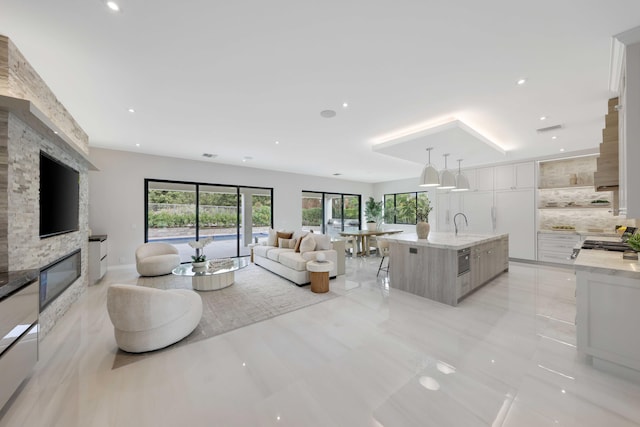 tiled living room featuring a fireplace and sink