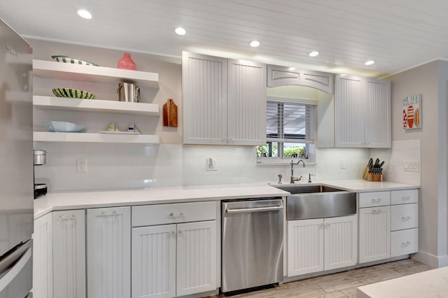 kitchen featuring decorative backsplash, appliances with stainless steel finishes, light hardwood / wood-style flooring, and sink