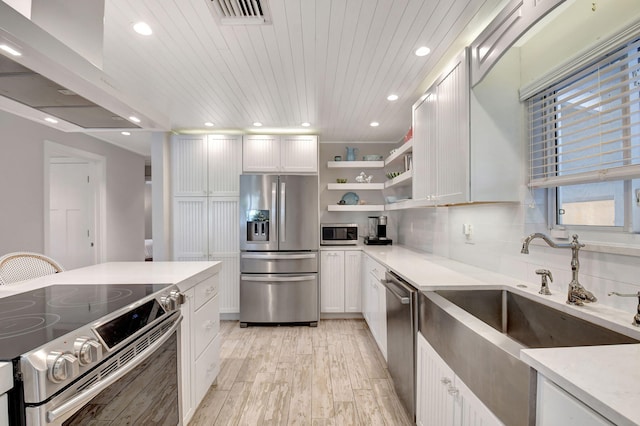 kitchen featuring white cabinetry, light wood-type flooring, and appliances with stainless steel finishes