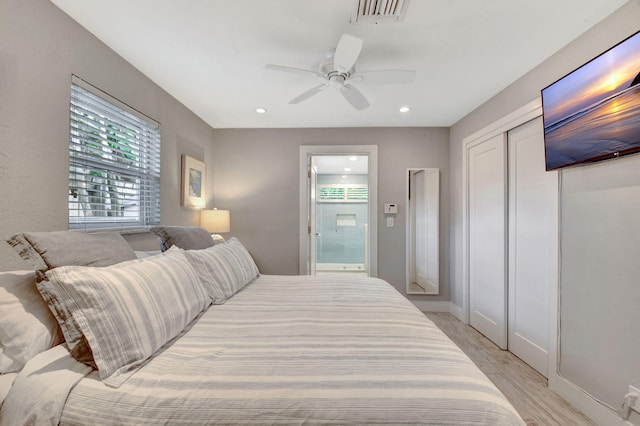 bedroom featuring connected bathroom, ceiling fan, a closet, and light wood-type flooring