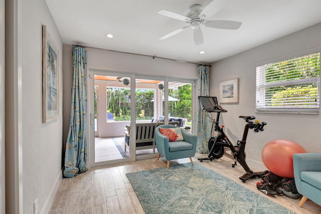 exercise room with light hardwood / wood-style flooring and ceiling fan