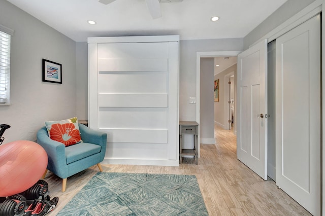 living area with ceiling fan and light hardwood / wood-style floors