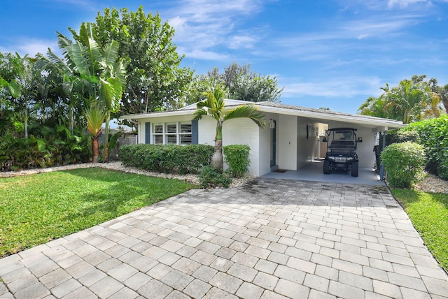 ranch-style house featuring a front lawn and a carport