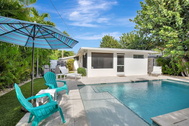 view of swimming pool with a patio and a sunroom