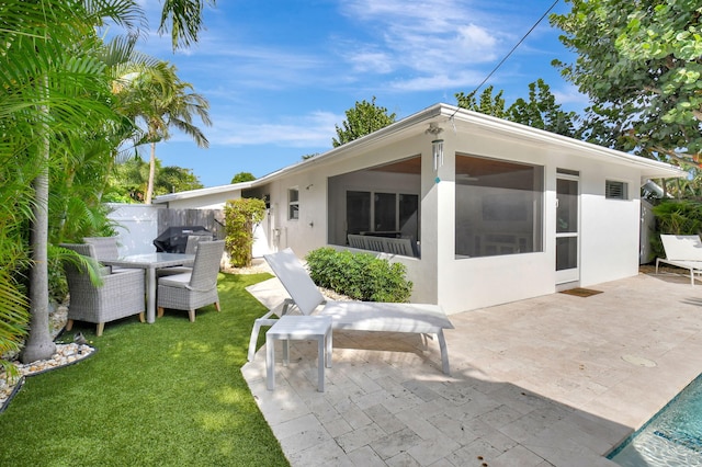 rear view of house with a lawn and a patio