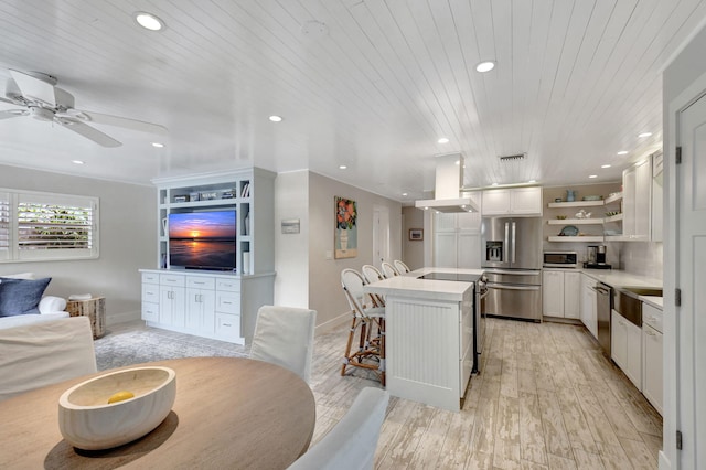 kitchen with white cabinets, appliances with stainless steel finishes, a kitchen island, a kitchen bar, and wood ceiling