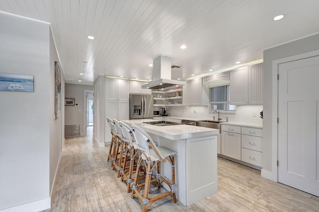 kitchen with white cabinets, island range hood, a kitchen island, and stainless steel refrigerator with ice dispenser