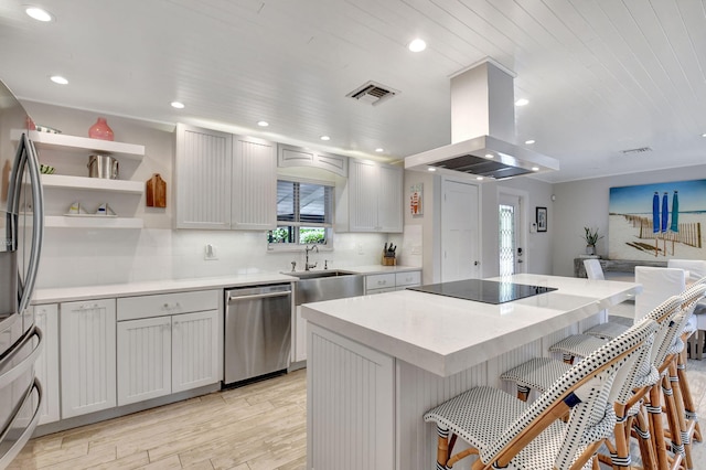 kitchen featuring wooden ceiling, island exhaust hood, a breakfast bar, a kitchen island, and appliances with stainless steel finishes