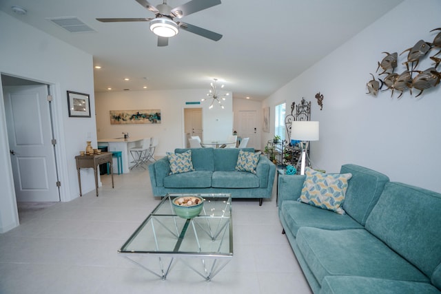 living room featuring light tile patterned floors, ceiling fan with notable chandelier, and lofted ceiling