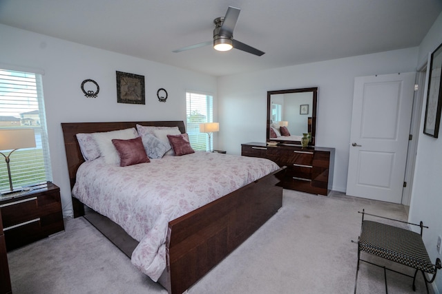 carpeted bedroom with multiple windows and ceiling fan