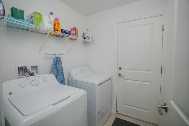 laundry area featuring washing machine and clothes dryer and light tile patterned floors