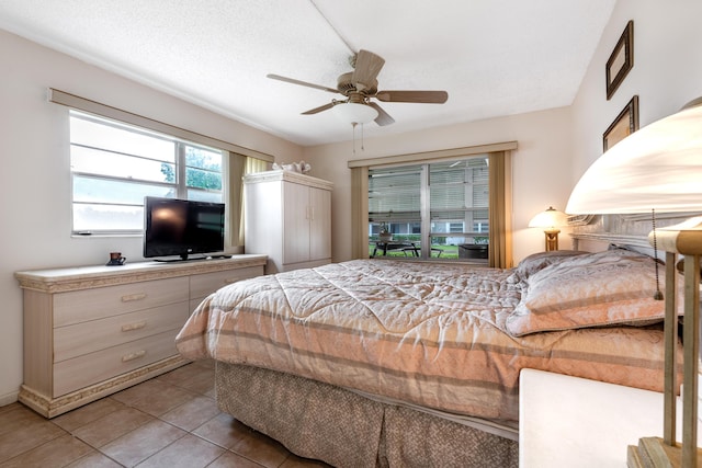 tiled bedroom featuring a textured ceiling and ceiling fan