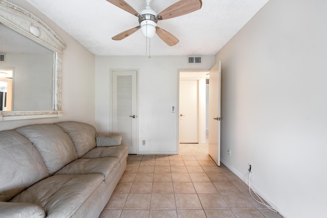 tiled living room featuring a textured ceiling and ceiling fan