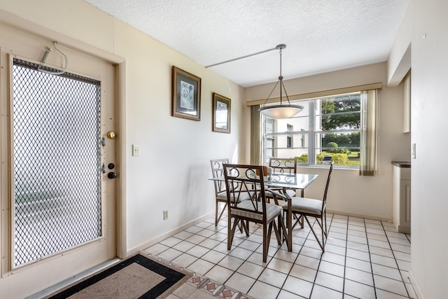 dining space featuring a textured ceiling and light tile patterned flooring