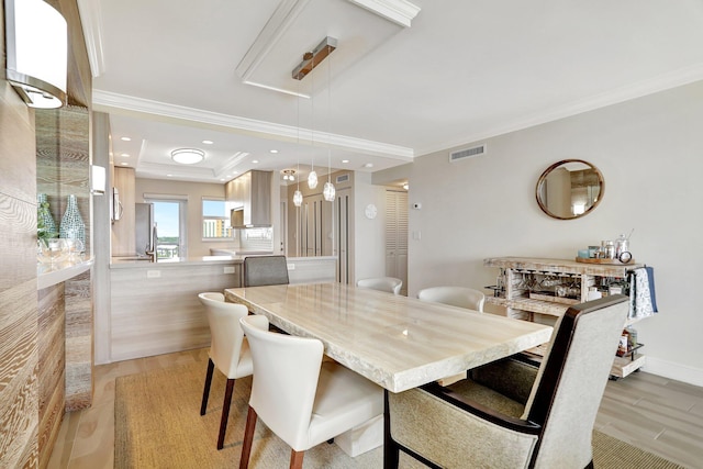 dining room featuring light wood-type flooring and crown molding