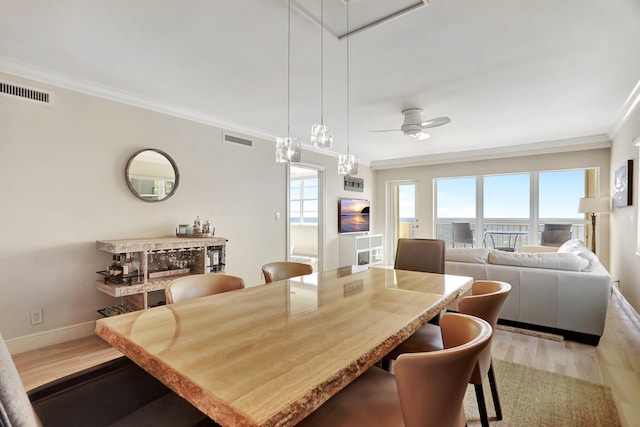 dining room featuring light hardwood / wood-style flooring, ceiling fan, and ornamental molding