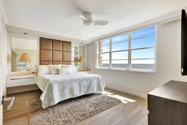 bedroom featuring light hardwood / wood-style floors, ceiling fan, and crown molding