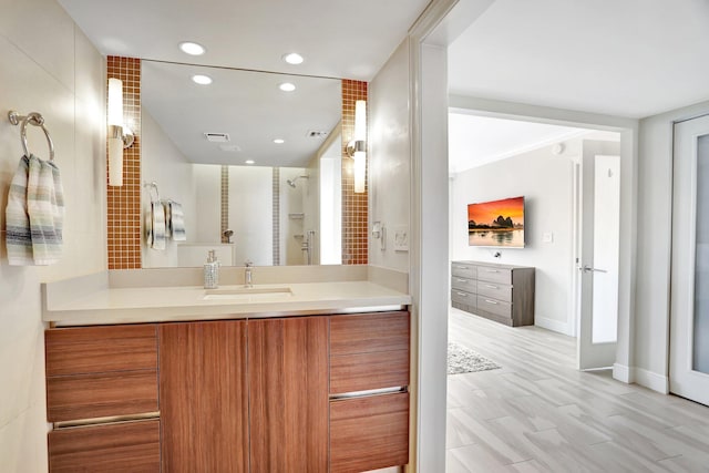 bathroom featuring hardwood / wood-style flooring, vanity, and a shower