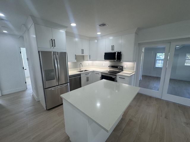 kitchen featuring white cabinetry, sink, appliances with stainless steel finishes, and light hardwood / wood-style flooring