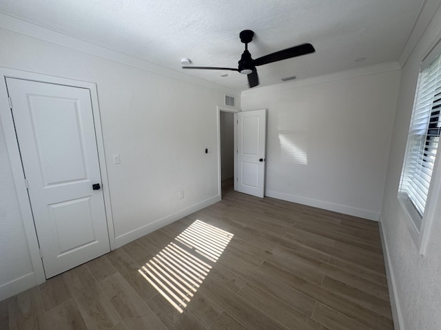 unfurnished bedroom with hardwood / wood-style floors, ceiling fan, ornamental molding, a textured ceiling, and a closet