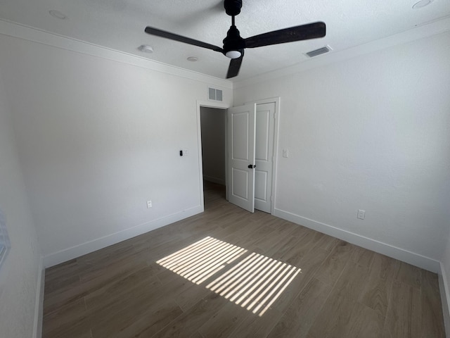 unfurnished room featuring hardwood / wood-style floors, ceiling fan, and crown molding