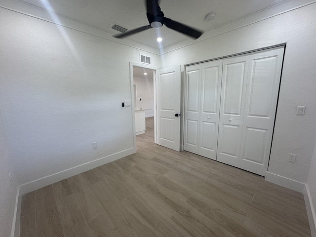 unfurnished bedroom featuring ceiling fan, a closet, and light hardwood / wood-style flooring