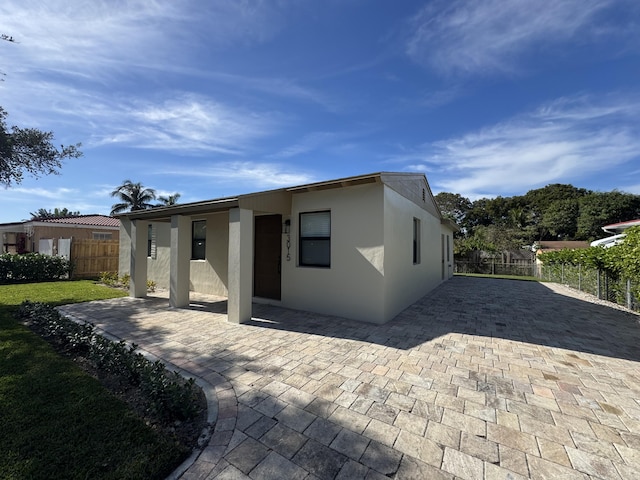 3015 Robert Rd, West Palm Beach, FL 33405 - rear view of property with stucco siding and a patio area