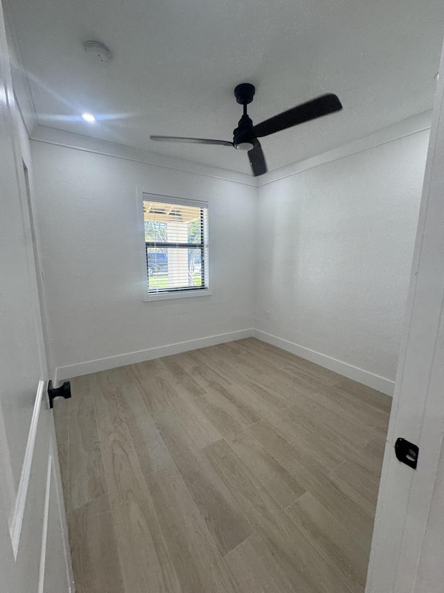 spare room featuring light hardwood / wood-style flooring and ceiling fan