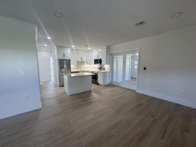 kitchen featuring a center island, crown molding, light hardwood / wood-style flooring, appliances with stainless steel finishes, and white cabinetry