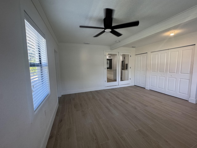 unfurnished bedroom featuring french doors, ceiling fan, ornamental molding, a textured ceiling, and wood-type flooring