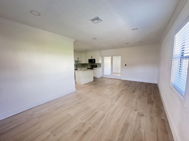 unfurnished living room featuring light wood-type flooring and ornamental molding