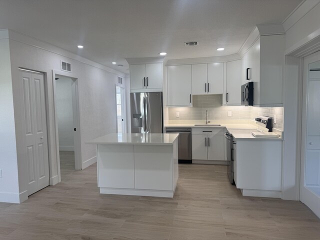 3015 Robert Rd, West Palm Beach, FL 33405 - kitchen featuring stainless steel appliances, tasteful backsplash, light countertops, light wood-style floors, and recessed lighting
